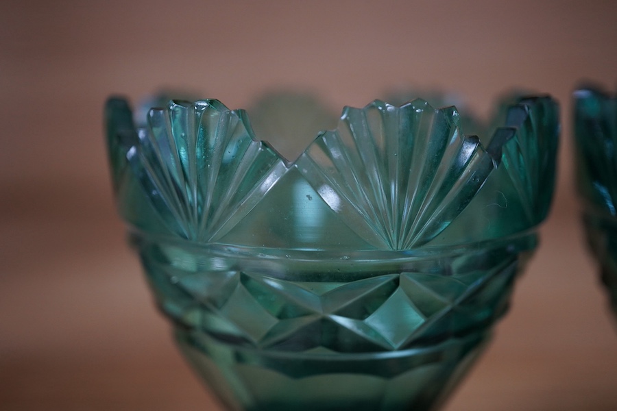 A pair of Regency dark green glass fan cut salts, on square plinths, 9cm. Condition - good, one small chip